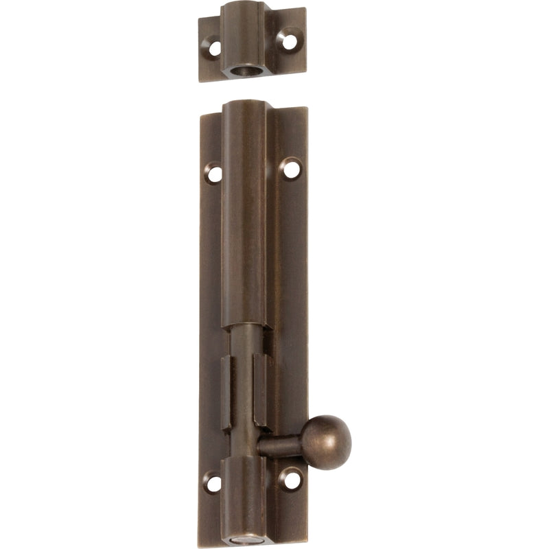 Tradco barrel bolt lock in black finish, mounted on wooden door for secure fastening and door security.
