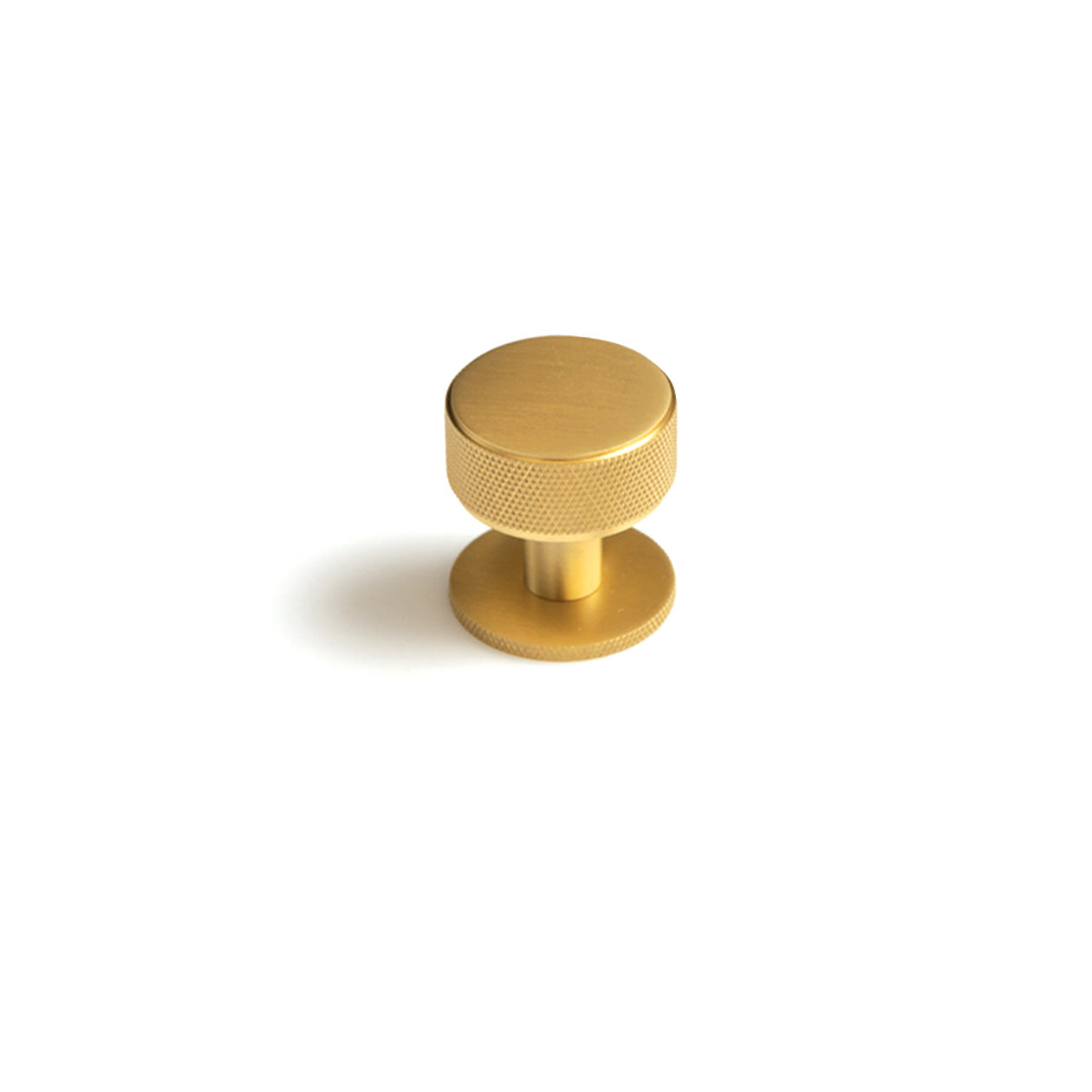 Momo Belgravia knurled cabinet knob in brushed brass finish mounted on a wooden cabinet door.