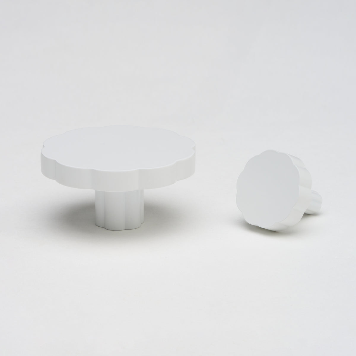 Lo & Co Tropez Knob cabinet hardware in brushed nickel with a sleek, rounded design, mounted on a wooden surface.