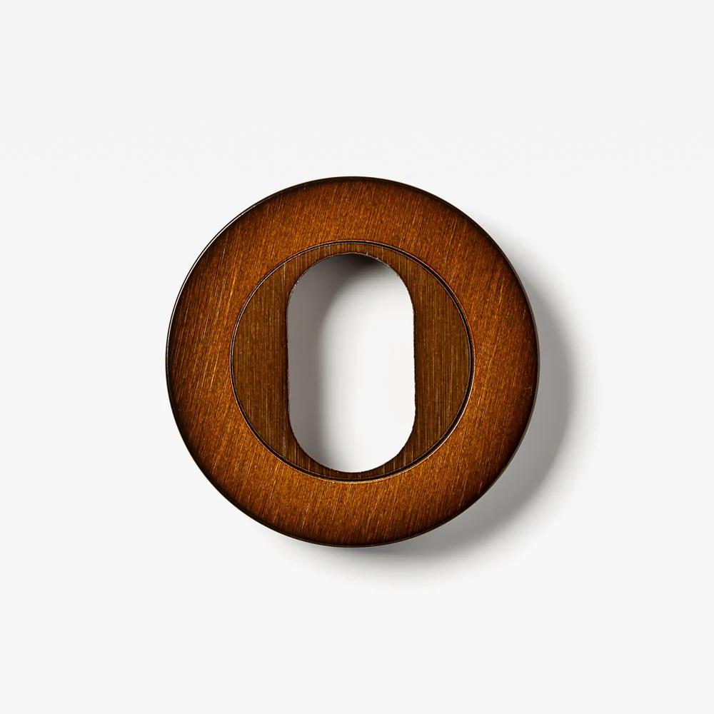 Round oval cylinder escutcheon from Lo & Co Interiors, architectural hardware with polished brass finish, showing its smooth, rounded design.