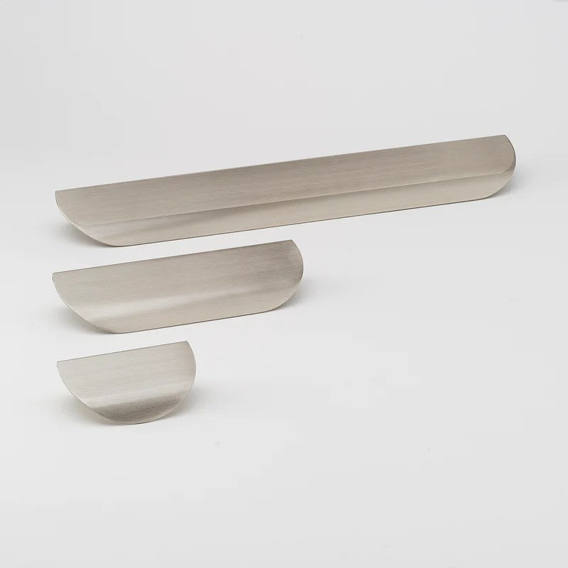 Brushed nickel Lo & Co Carlisle cabinet pull from Lo & Co Interiors, featuring sleek modern design on a wooden cabinet door.
