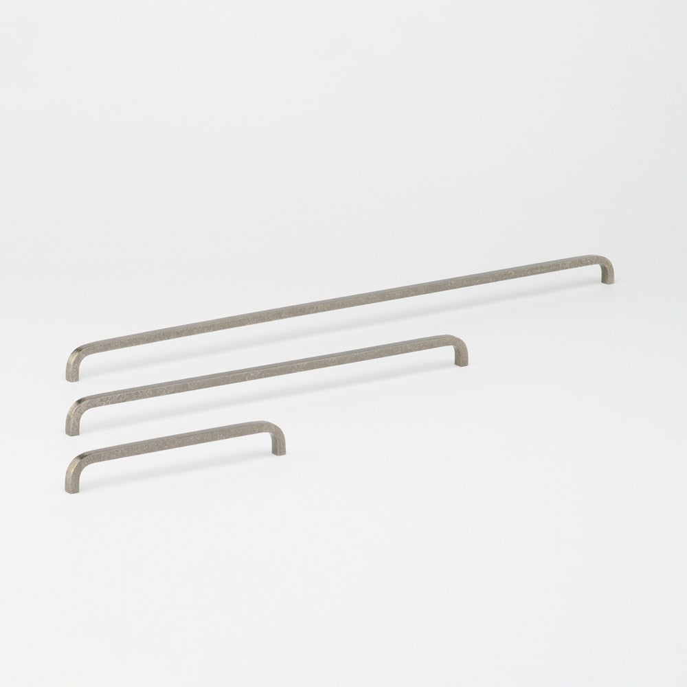 Lo & Co Interiors Curve Pull cabinet hardware in matte bronze, featuring a sleek, curved design for modern kitchen or furniture use.