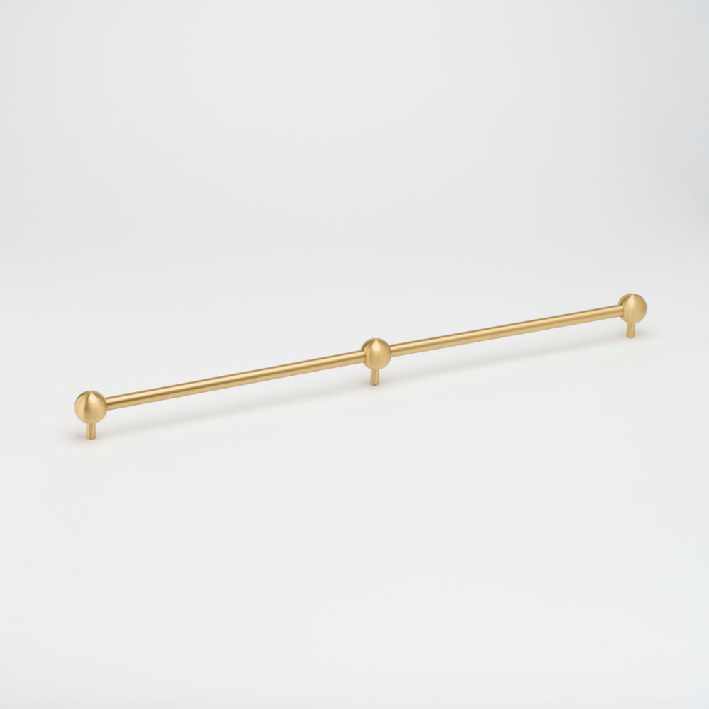 Lo & Co Interiors Sphere Appliance Pull, cabinet hardware with a sleek round design in a brushed finish, mounted on a cabinet door.