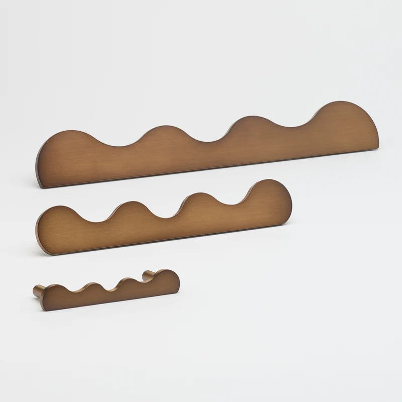 Lo & Co Karu pull handle, architectural hardware in brushed bronze finish, mounted on a door or drawer.