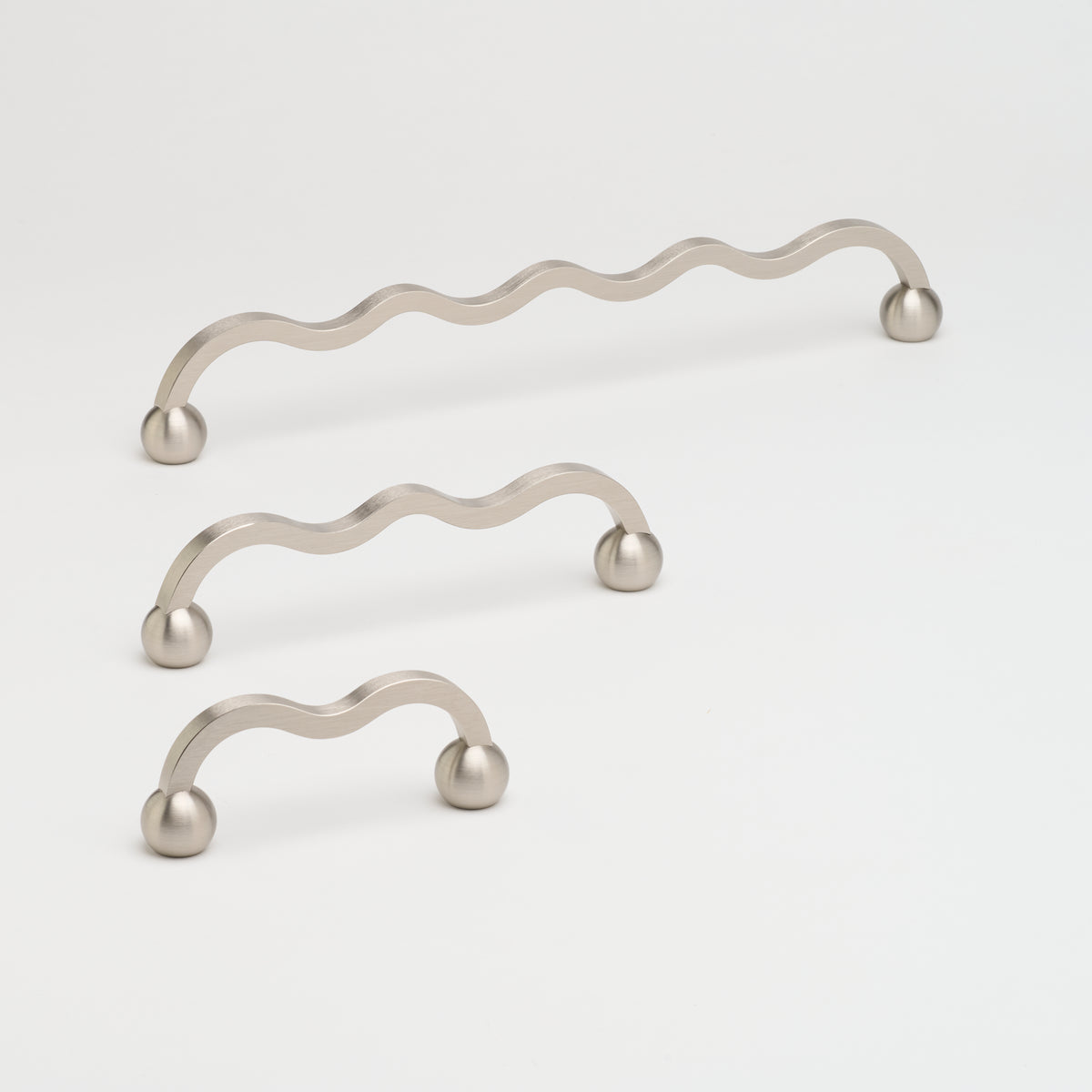 Brushed nickel Capri Pull cabinet hardware by Lo & Co Interiors mounted on a cabinet door.