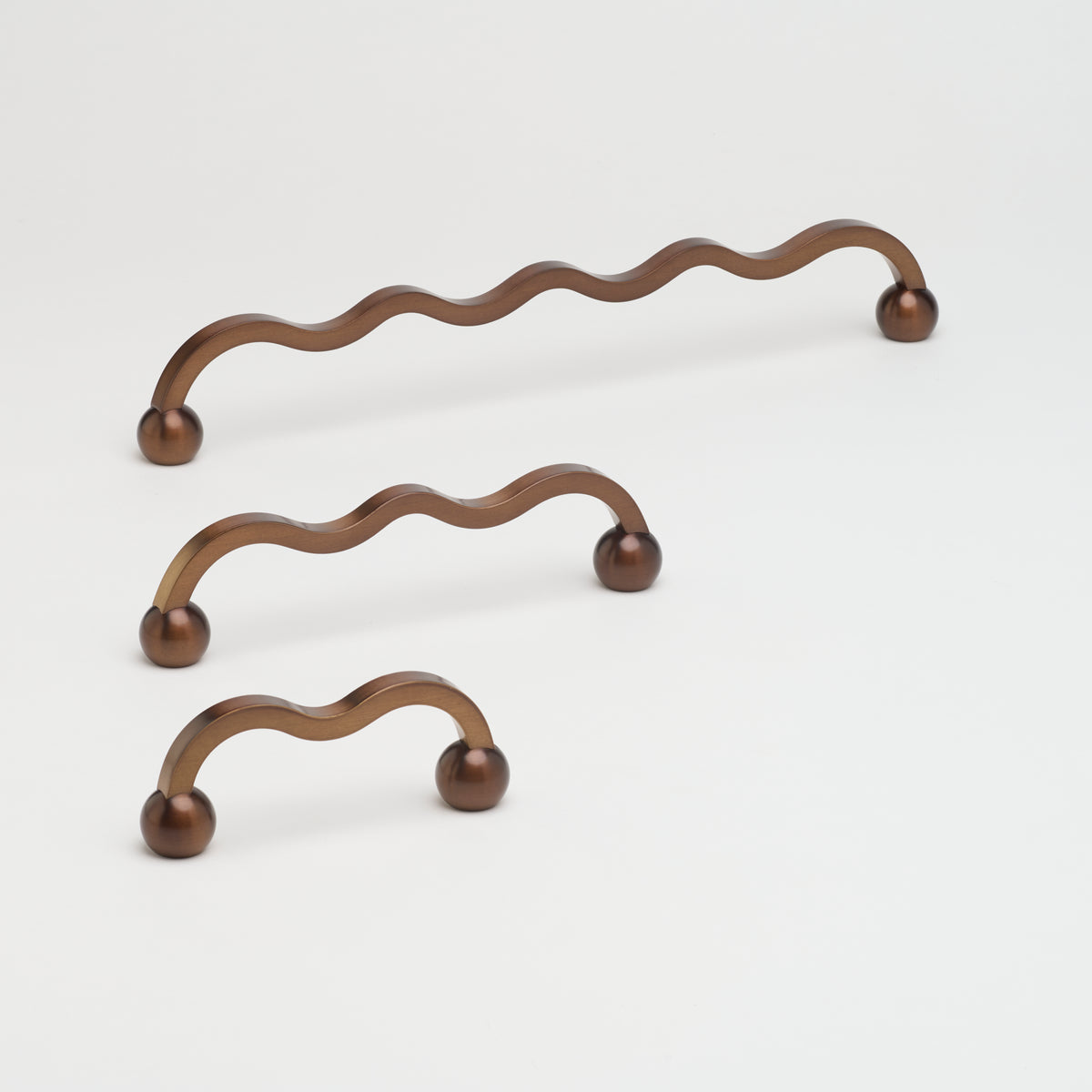 Capri Pull cabinet hardware by Lo & Co Interiors, brushed bronze finish, sleek modern handle for kitchen or bathroom cabinets.