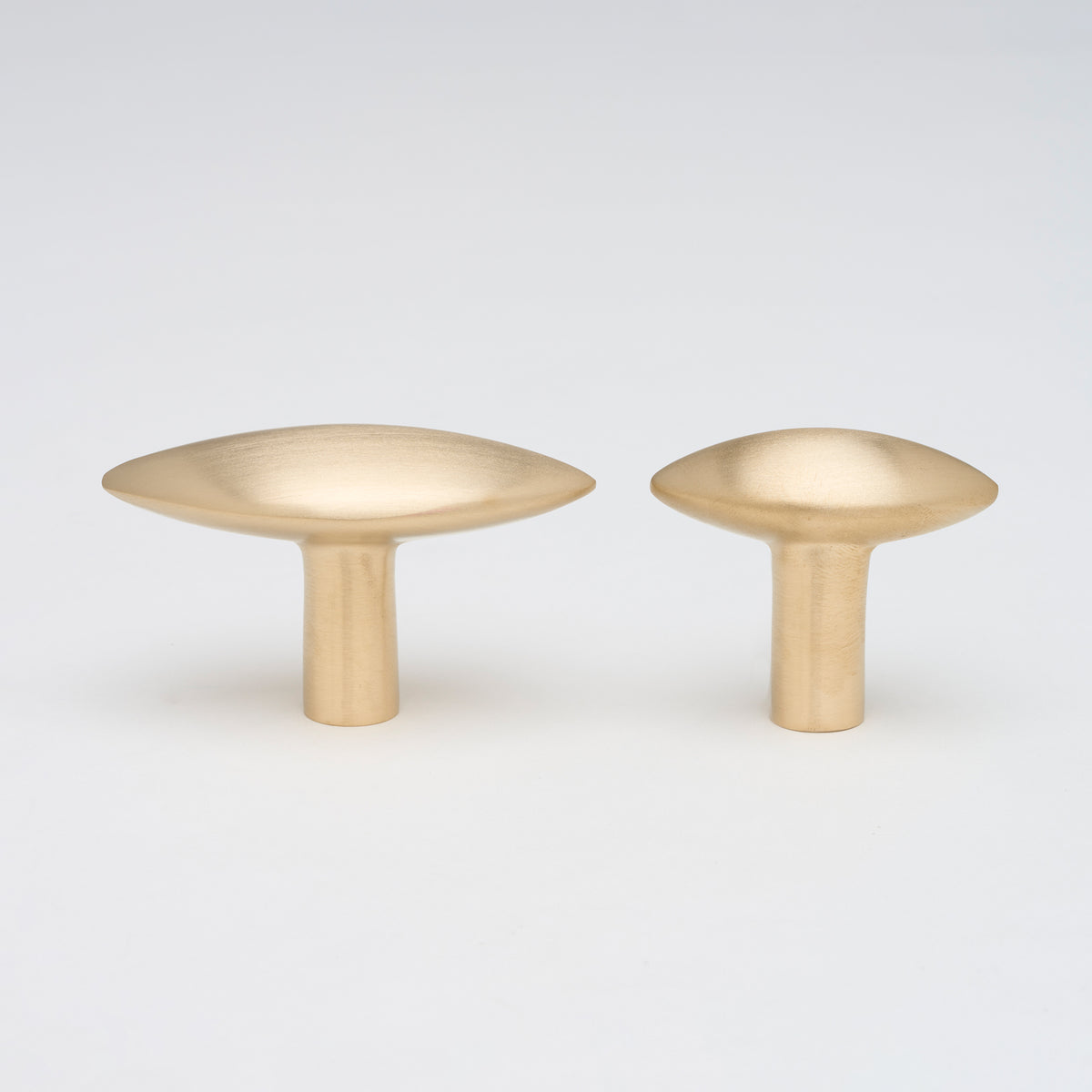 Lo & Co Almond Knob cabinet hardware showing a smooth, almond-shaped metal knob on a wooden cabinet surface.