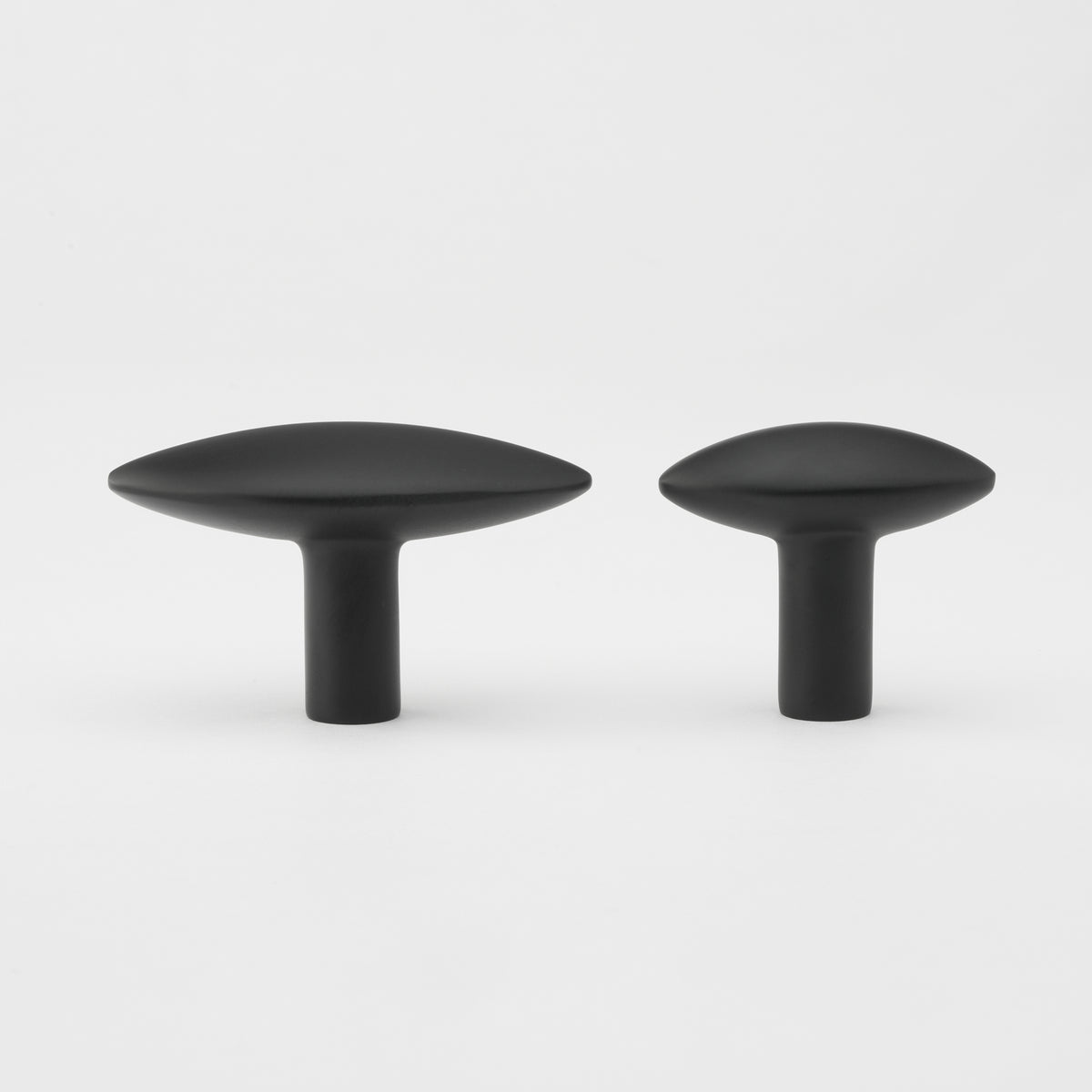 Lo & Co Almond Knob cabinet hardware in brushed nickel, round with a smooth almond shape, mounted on a wooden cabinet door