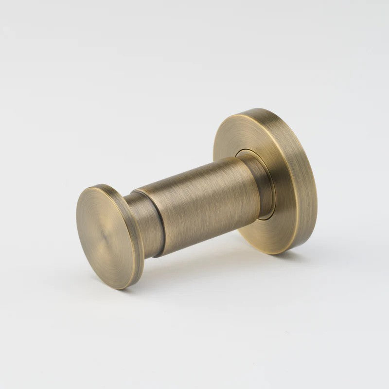 Lo & Co Lola towel hook mounted on wall, showcasing sleek architectural hardware design in bronze finish.
