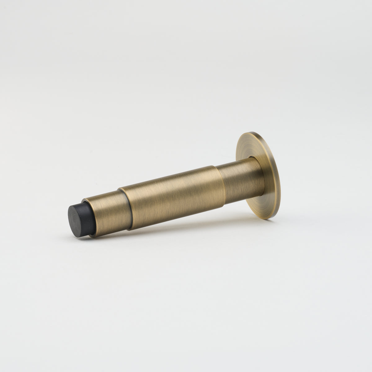 Lo & Co Lola doorstop in antique brass finish, decorative architectural hardware for securing doors.