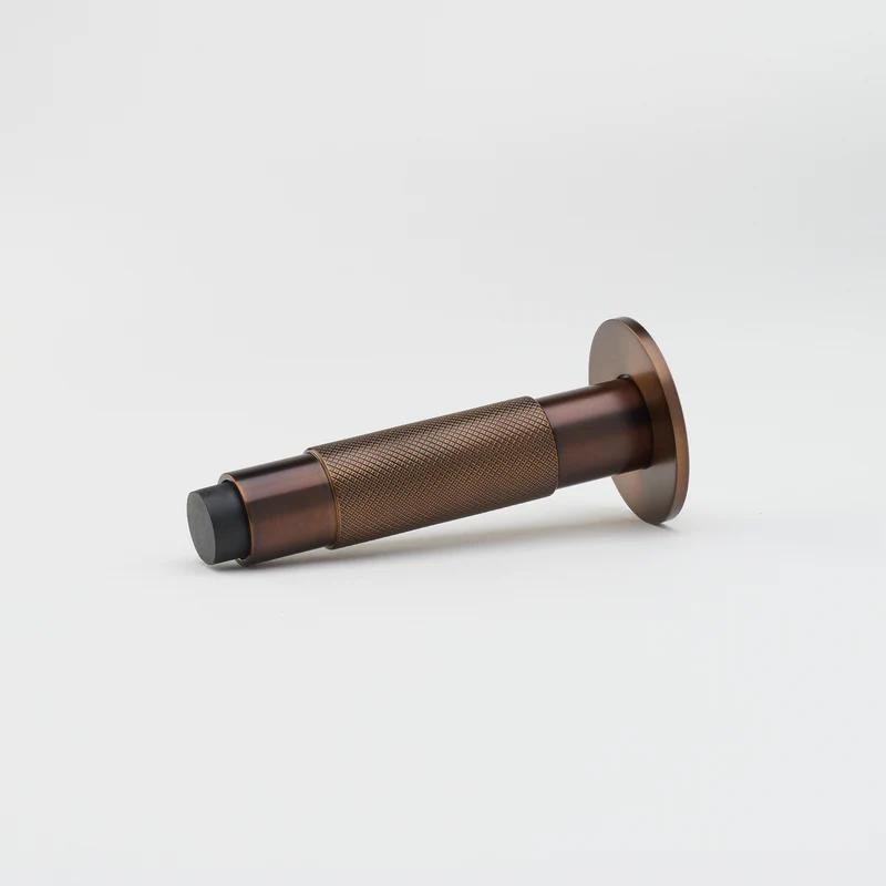 Lo & Co Knurled Kintore doorstop with brass finish, featuring textured knurled design and sturdy metal construction.