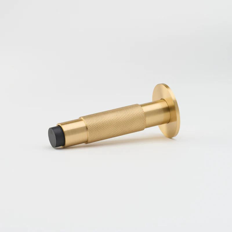 Lo & Co Interiors knurled Kintore doorstop with textured metal finish, standing upright on a flat surface.