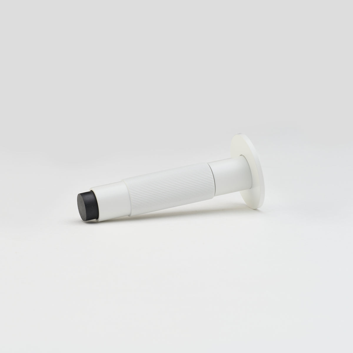 Lo & Co Linear Doorstop mounted on wall, modern architectural hardware in sleek finish, part of Lo & Co Interiors collection.