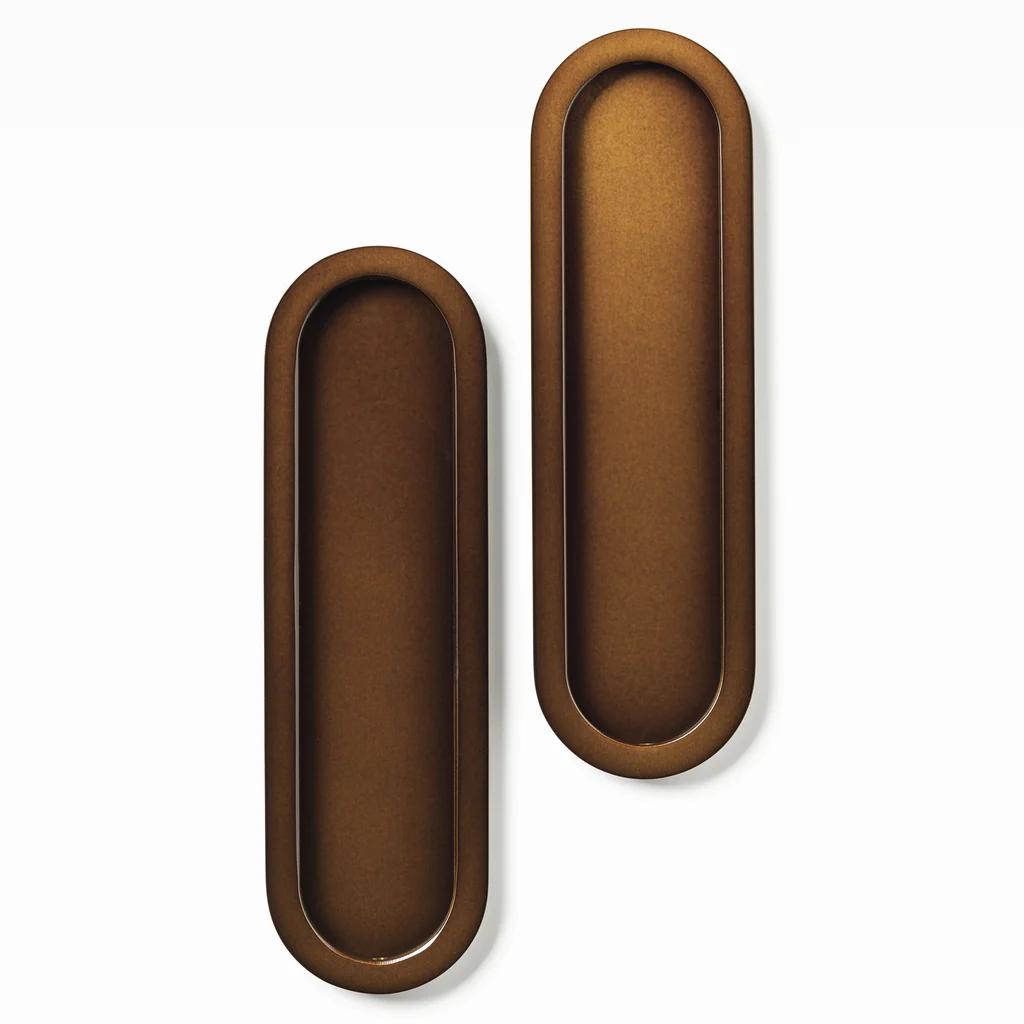 Lo & Co Oval Flush Pull Set in brushed bronze, architectural hardware with sleek oval design, mounted on a door for modern decor.
