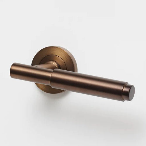 Lo & Co Lola Lever door handle in bronze finish, showcasing its sleek modern design and ergonomic shape.