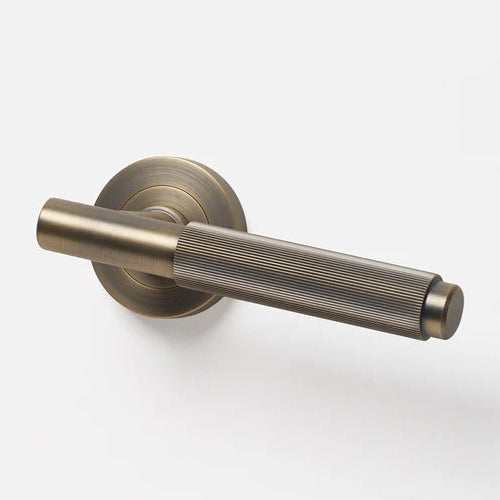 Lo & Co Linear Knurled Lever handle with textured finish, mounted on a door, showcasing modern door hardware design.
