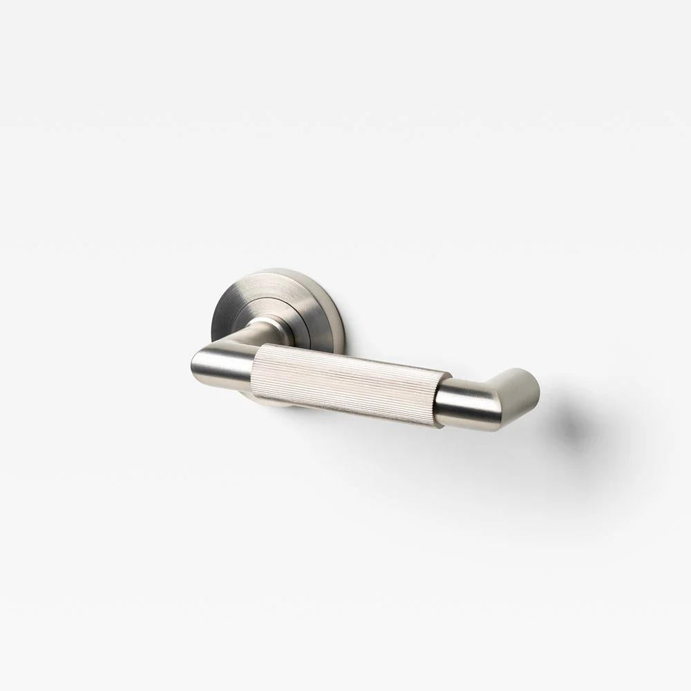 Lo & Co Linear Knurled Return Lever in brushed nickel, showing its sleek, textured metal handle design for cabinetry.