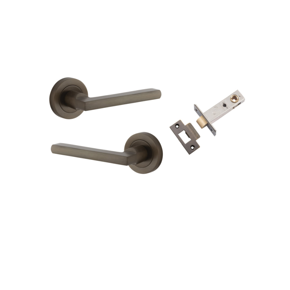 Pair of Iver Baltimore lever door handles on round rose, featuring a sleek brass finish and modern design.