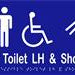Unisex Accessible Toilet LH & Shower Sign with Braille, Laminated Vinyl 300x150 Blue Over White in Blue