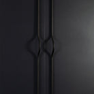 Momo BRAVE Bow Cabinet Pull Handles in black finish mounted on a cabinet door, showcasing sleek, curved design for kitchen or furniture.