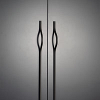Momo BRAVE Bow off-centred cabinet pull handle in matte black finish mounted on a wooden cabinet door.