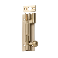 Tradco 75mm barrel bolt offset lock showing a metal latch with mounting screws on a wooden surface.