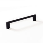 Momo BARRA D cabinet pull handle with a sleek metal finish, mounted on a wooden cabinet door for modern kitchen or furniture decor.
