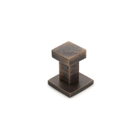 Castella Cast Square Wall Hook mounted on a wall, showing its sleek black metal design for hanging items.