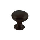Momo FLORENCIA plain cabinet knob in matte black finish, showing a sleek round design on a wooden cabinet door.