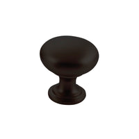 Momo FLORENCIA plain cabinet knob in matte black finish, showing a sleek round design on a wooden cabinet door.