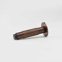 Lo & Co Knurled Kintore doorstop with brass finish, featuring textured knurled design and sturdy metal construction.