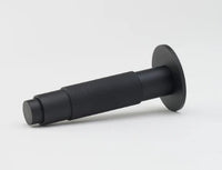 Lo & Co Interiors knurled Kintore doorstop in brushed metal finish, resting on a wooden floor.