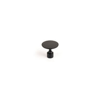 Momo FLOID cabinet knob in black, modern round design, mounted on a wooden cabinet door for stylish storage access.