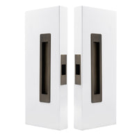 Windsor LUME sliding door flush pull passage set with two orange flush pulls on a door, modern hardware for sliding doors.