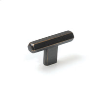 Momo Hendrix cabinet T-pull handle in antique brass finish, sleek design visible on a modern wooden cabinet door.