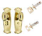 Pair of Tradco Bungalow knobs on long backplates, featuring vintage-style brass hardware for classic cabinet or door decor.