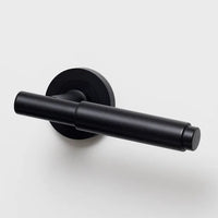 Lo & Co Lola Lever door handle in matte black finish, mounted on a wooden door with visible hardware and modern design details.