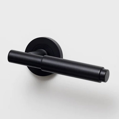 Lo & Co Lola Lever door handle in matte black finish, mounted on a wooden door with visible hardware and modern design details.