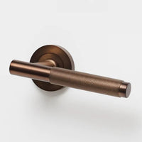 Lo & Co Kintore knurled lever handle in brass, showing its textured surface and sleek design for interior cabinetry or furniture.