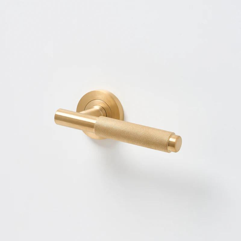 Lo & Co Kintore knurled lever handle in black finish, mounted on a door with visible textured surface and modern design.