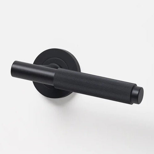 Lo & Co Linear Knurled Lever door handle in brushed metal finish, showing textured grip and sleek modern design.
