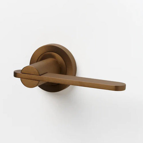 Lo & Co Intersect Lever door handle in brushed bronze finish, showcasing its modern design and sleek ergonomic shape.