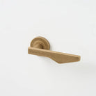 Lo & Co Interiors Outline C Lever door handle in bronze finish, showing the sleek, modern design on a door.