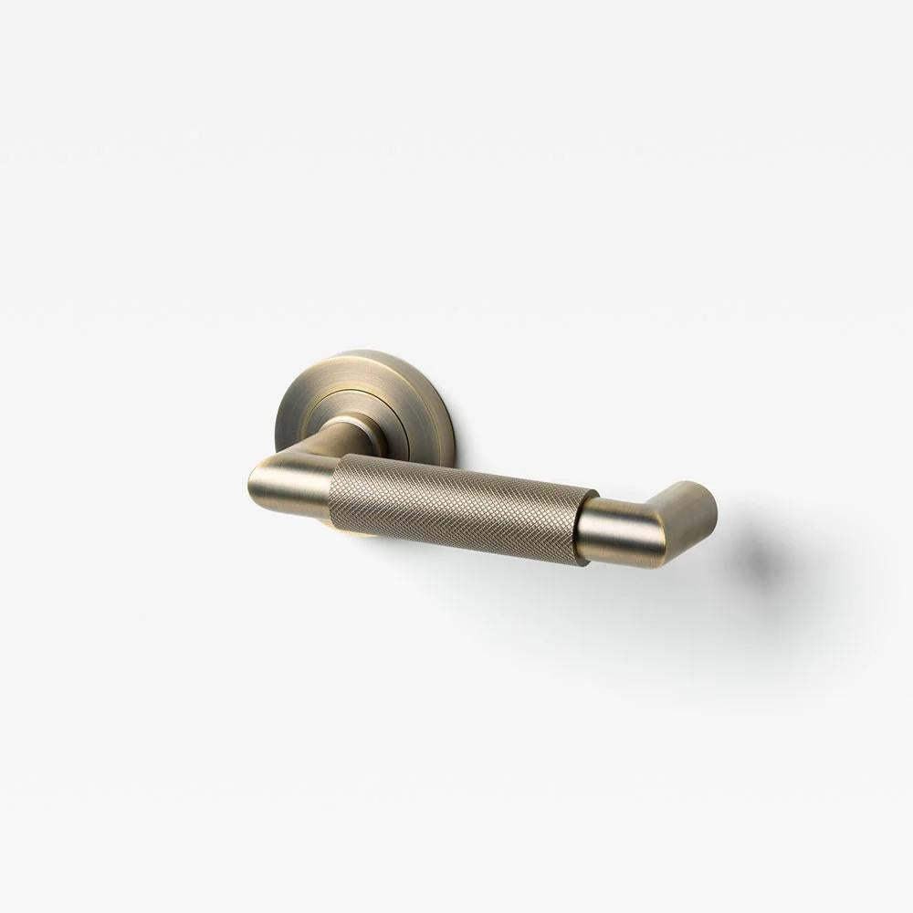 Lo & Co Kintore knurled return lever for door hardware, shown in close-up with textured metal finish.