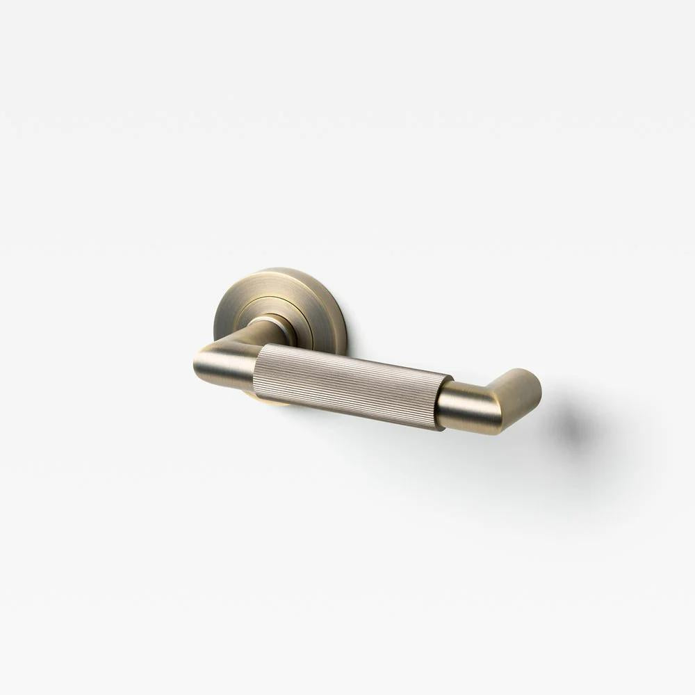 Lo & Co Linear Knurled Return Lever in brushed metal finish, showing its sleek design and textured grip for interior doors.
