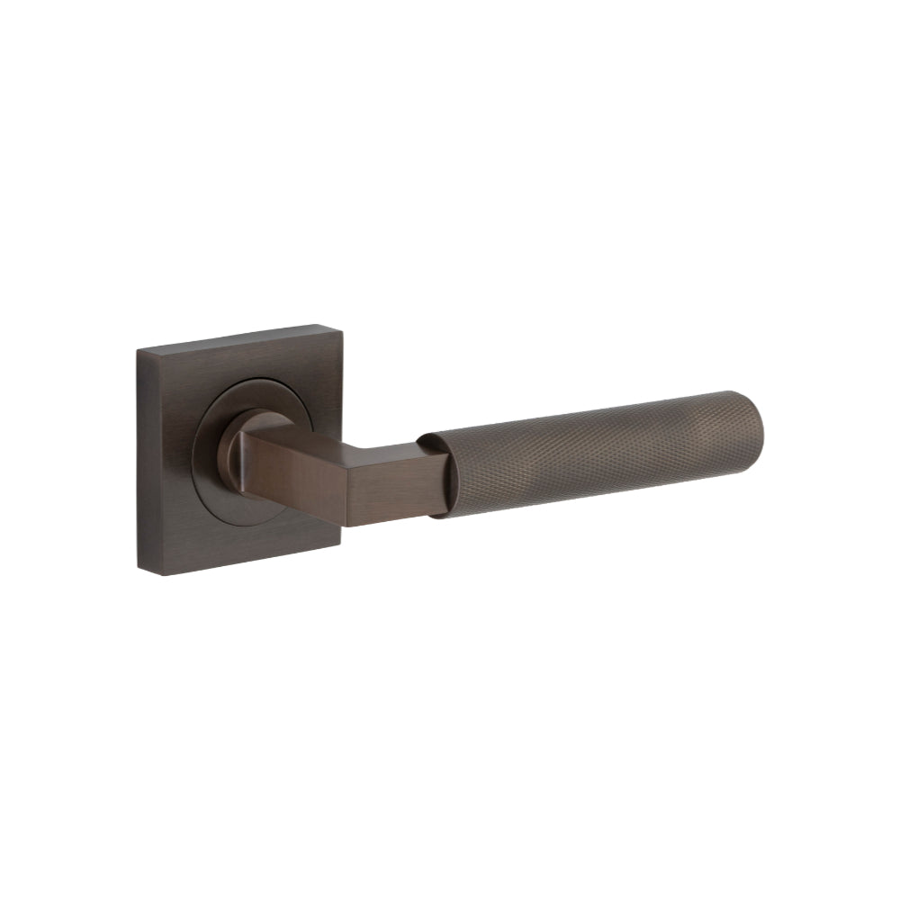 Pair of Iver Brunswick lever door handles on square rose, featuring elegant metal design and polished finish.