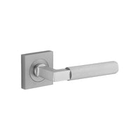 Pair of Iver Brunswick lever handles on square rose plates, featuring a sleek, modern design for interior doors.