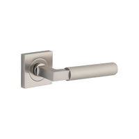 Pair of Iver Brunswick lever door handles on square rose, featuring a polished metal finish and modern design.