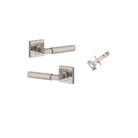 Pair of Iver Brunswick lever door handles on square rose in antique brass finish, showing detailed polished brass surfaces.