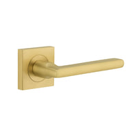 Pair of Iver Baltimore lever door handles on square rose, showcasing sleek brass finish and modern design.